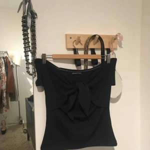  - Supersöt svart bardot topp med knytning fram! Snygg stretchig off-shoulder som sitter så snyggt på.