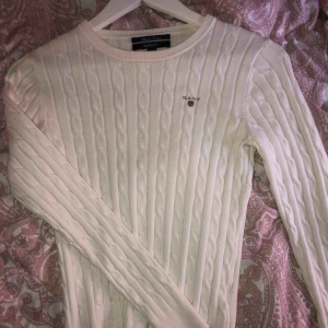  - Vit kabelstickad gant tröja, använd fåtal gånger men i väldigt bra skick. Kan fraktas men köparen står för frakten!