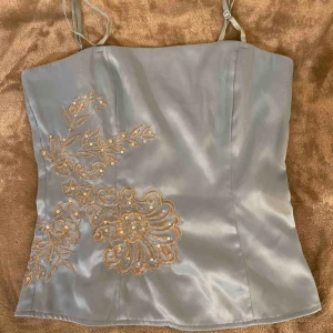 Topp från Vila - Smickrande topp från Vila. Passar även mig som vanligtvis är S. Axelbanden är avtagbara och justerbara. Passformen är tajtare, som en korsett ungefär (dragkedja på sidan) 😛 Superfin blå färg! Köparen står för 🚚. 🥰💕