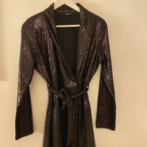 Gina Tricot strl M - Snygg klänning med knytning från Gina Tricot i strl M. Ursnygg till nyår/fester. Kan mötas i Halmstad eller frakta (fraktpris tillkommer)