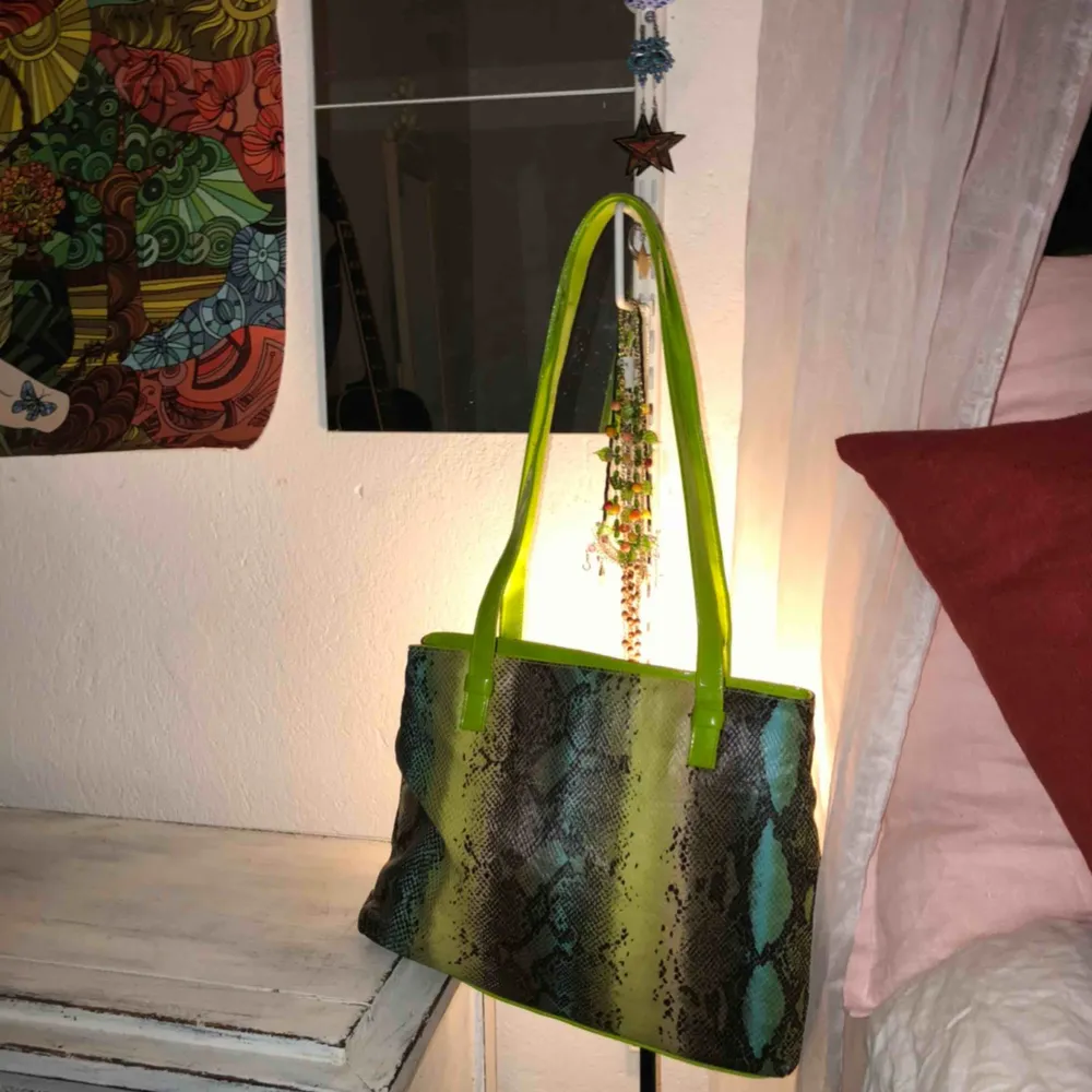 Cool grön och blå handväska med speciellt mönster och lackade gröna band. Köpt på humana förra månaden till en temafest -nu är den inte längre till användning. Neon o läderimitation design -80tals vibes.. Väskor.