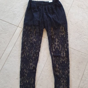 Snygga Leggings med spets - Köpta på Shock, spets på benen med svarta shorts fastsydda längst upp. Passar som "byxor" eller leggings/tights att ha under något lite längre! Tyvärr för små för mig. Det står strl S-M men skulle säga att det mer är en XS till liten S. Pris är med frakt