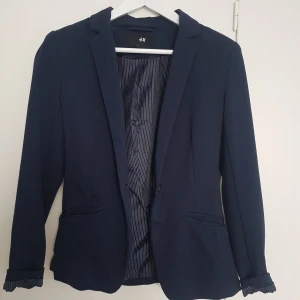 marinblå kavaj h&m 34 - Mörkblå kavaj / blazer i mjukare tyg. Storlek 34. Fickor i sidorna och innerfoder i randigt tyg.
