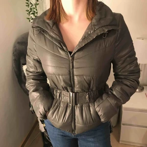  - Militärgrön dunjacka i polyester med snyggt skärp från H&M Perfekt för höst eller vår väder!