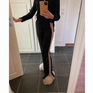  - Svarta byxor med en beige rand, från H&M.  Storlek: 32 , skulle även passa en 34/XS  