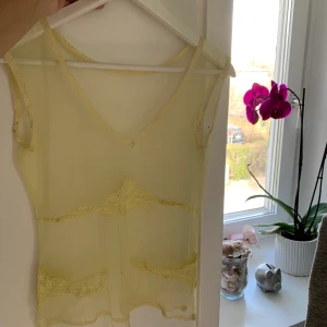 Gult mesh linne - Gult mesh linne med brodyr under brösten och på magen. Super fint på sommaren 💕💜🧡 köparen står för frakten. Kan frakta flera plagg tsm så kolla in min profil för mer kläder :)