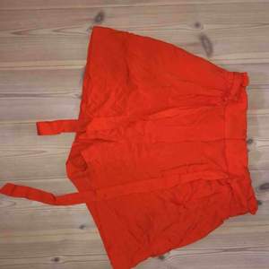 Sköna luftiga shorts i en somrig orange färg! Band som går att knyta eller bara låta hänga samt två spännen i midjan.