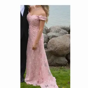Säljer min balklänning som använts 2 ggr. En väldigt elegant klänning med broderade blommor och rosa stenar på, samt ett jättefint släp. Jag är 1,62 och hade 5 cm klackar på bilden. 