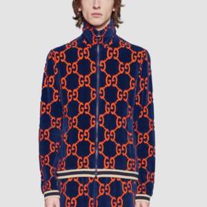 These blue and orange Gucci GG chenille cotton blend sweat feature an elasticated waistband, an all-over orange GG logo pattern, two side pockets, white and blue web trims at the side and a straight leg complete with white and web cuffs. 