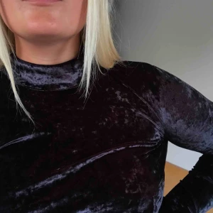  - Svart halvpolo i velour. Långa ärmar och lite kortare i midjan. Figurnära passform med dragkedja i nacken. Skimrar lite i mörkrött i vissa ljus. Frakt tillkommer <3 