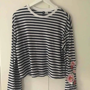  - Randig tröja från hm. Blommönster på ärmarna. 20kr + frakt. Kan mötas i tranåsområdet och i Sthlm. 