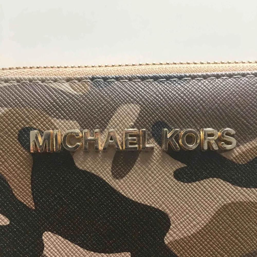 Fake Michael Kors plånbok med militärprint och gulddetaljer. Plånboken är mycket rymlig innehållande 12 kortfack och myntfack samt delare där man kan förvara sedlar och kvitton🌼. Accessoarer.