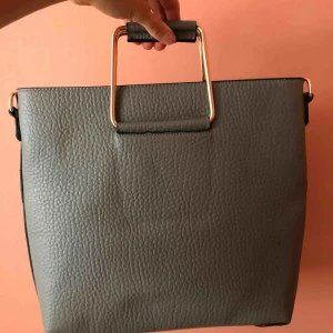  - Ny väska i skinnimitation. Grå med gulddetaljer. Många fack inuti, aldrig använd. Mötas upp i Uppsala eller frakt 60 ⭐️⭐️⭐️