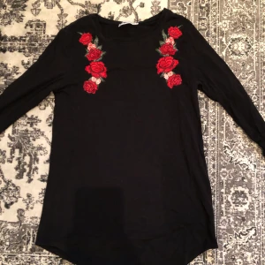 Svart långärmad tröja i XS - Svart långärmad med rosor i storlek XS, aldrig använd. Passar S också 