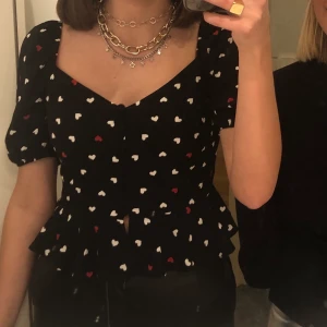Topp med hjärtan  - Säljer denna fina topp! Perfekt till både fest och vardag. Endast använd en gång då jag tyvärr växt ur den. Passar både S och XS! 