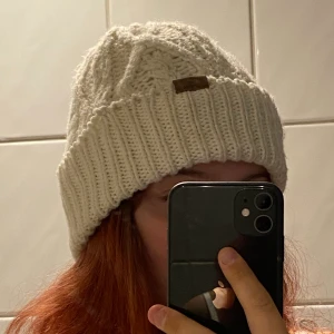 Mössa - Jätte gullig vit flätstickad mössa🤍 med en liten mocka färgad tag i mitten, använd men är i bra skick✨ köparen betalar frakten!