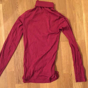 Röd polo - Röd polo i syntet material, storlek S, köpare står för frakt.