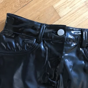 Svart kjol i vinyl/blankt fakeskinn, XS. - Vinylkjol från Asos, UK 4. Aldrig använd. 