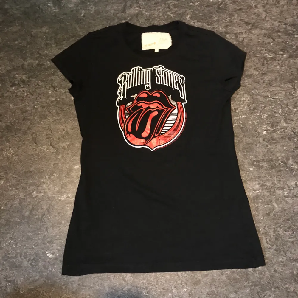 En svart band tröja med Rolling Stones motiv med glitter. Oanvänd. Skulle se bra ut om man cropped den men det låter jag köparen bestämma. Kan mötas upp i Stockholm eller posta. Frakt 44kr. T-shirts.