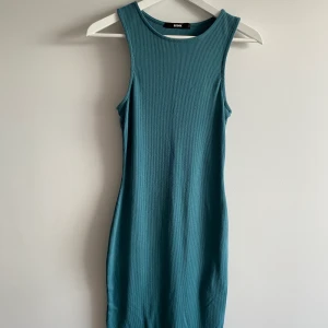 Turkos Mididress  - En mycket snygg klänning till sommaren! Den är väl använd men i gott skick. Klänningen är mycket stretchig som gör att alla mellan S-L kan ha på sig den! En favorit hos mig. Klänningen går ner till knäna. 