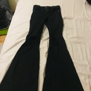 Dr denim bootcut - Svarta dr denim bootcut, modell Macy med hål på knäna. Storlek XS, använt fåtal gånger så väldigt bra skick.