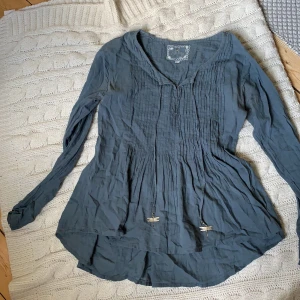 Fira blus - Blågrå blus ifrån fira med fina detaljer. Nypris: 650kr (FRAKT TILLKOMMER)