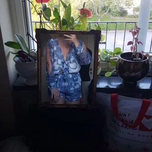 Mönstrad byxdress från BikBok säljes - Denna fina byxdress från BikBok säljes då den inte längre används. Väldigt fint mönster. Stäng med knyt framme vid brösten. Ärmarna är som öppna, samt går att slänga in innanför om man vill ha den kortärmad.Passar S/M.Går som ett par shorts. Mkt bra skick