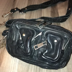 Liten svart Nunoo väska i skinn - Fint skick. Modell Helena. Extra axelremsband medföljer. Skickas mot fraktkostnad.