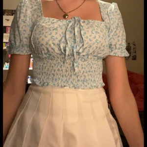 Gullig Ljus blå topp med ljusblå fjärilar på - Tunt och somrigt material med puffärmar. Man kan knyta bandet hur hårt man vill.