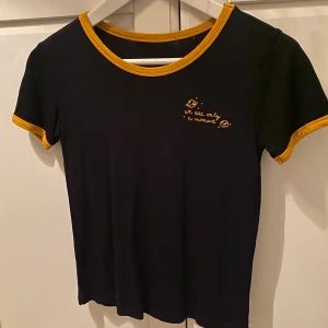 T-shirt  - En svart T-shirt jag använt 3-4 gånger med en gullig text vid sidan av bröstet där det står we are just a moment men Saturnus jorden och stjärnor runt omkring. 