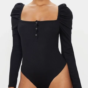 Black Puff tröja  - Säljer denna tröja ifrån PLT. Absolut aldrig använt. Tajt, knappar vid bröstet ifall man vill knäppa upp. Det är även en body, och har puff vid armarna.