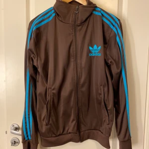 Kofta adidas - En adidas kofta. Med en unik färg och skönt material. Har lite märken på ena fickan som knappt syns. Pris kan diskuteras!