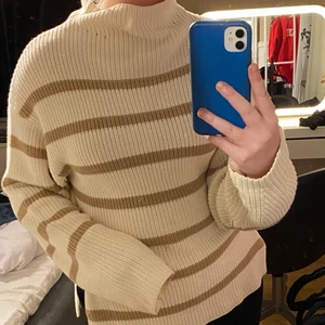 Stickad tröja - VÄRLDENS skönaste tyg! Jätte unik urringning vid halsen, det är inte en tajt polo utan snarare en lös polo vilket gör att den får as fint fall. Den är vit & beige & köpt på NAKD! Storlek S men är längre modell vilket blir superfint då det är slits på båda sidorna. Armarna är lite lösare vilket är superfint! Passar både xs, s & m! Köpt för 399kr. Skriv för fler bilder!