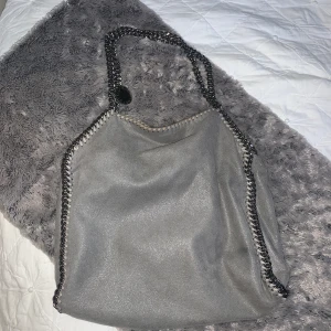 Stella McCartney väska - Säljer min stella McCartney väska eftersom jag inte använder längre, tyvärr har den 3 fimpmärken och därav det låga priset. Kvitto finns! 
