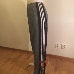 Adidas byxor - Gråa adidas byxor. Lite äldre modell av adidas. Passar S, M och L. Midjan är stor. Inget band i midjan så den får man fixa själv.