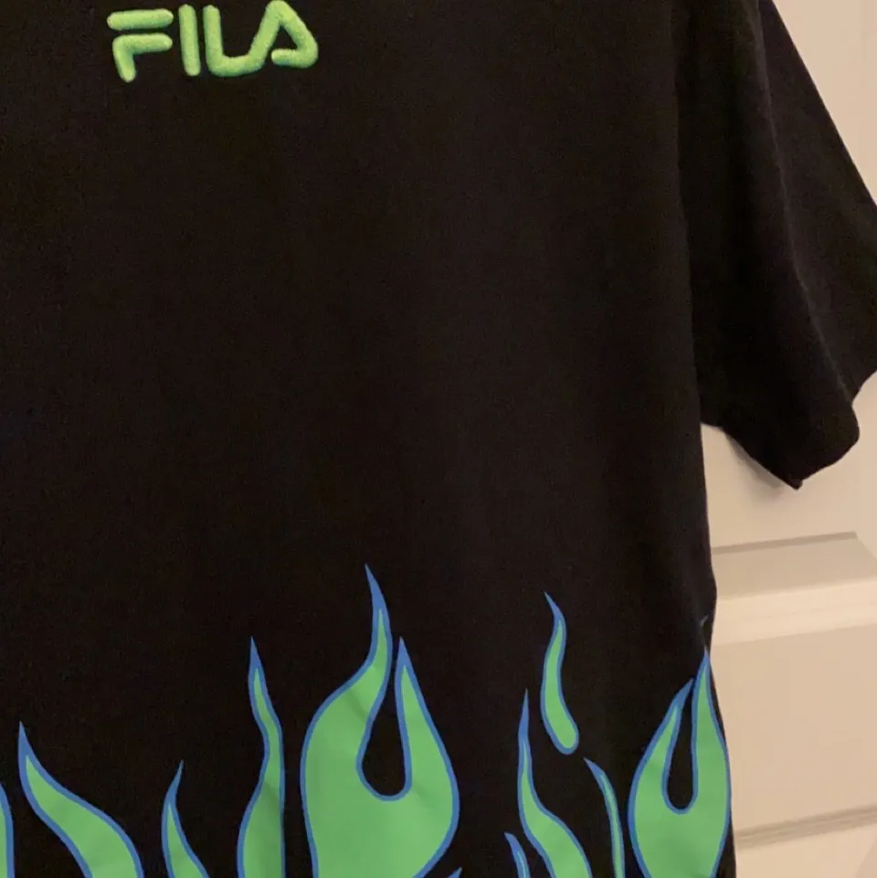 Fila t-shirt med grön eld. Jättesnygg och älskar den men den kommer tyvärr inte till användning:( . T-shirts.