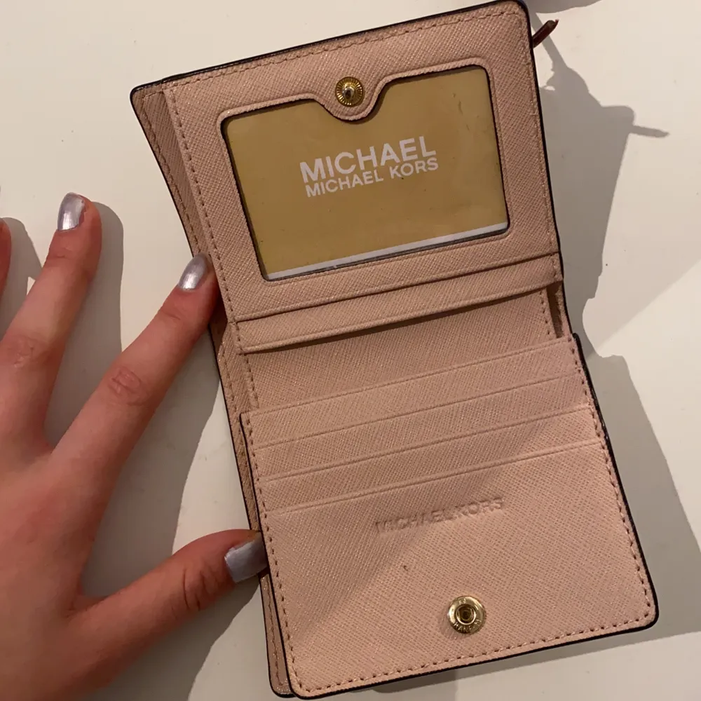 Jättefin äkta Michael kors plånbok! Den är i perfekt skick då den används väldigt lite varför jag också säljer den. Praktisk, rymmer väldigt många kort och kontanter! Den är jättefin färg rosa/beige. Köppte den för runt 6/700 kronor tror jag. 💕Men högsta bud får den!💕 minst 200kr  . Accessoarer.