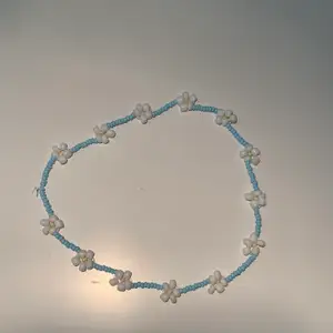 ett halsband med vita blommor! frakt 22kr!🤍☠️