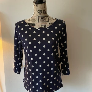 Prickig topp i linne - superskön! - Fin topp i linne, blå med vita prickar. Trekvartsarmar och dragkedja baktill.