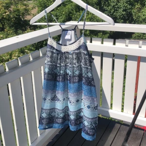 Topp/linne från Veromoda - Fint mönstrat linne i olika blåa färger. Virkat upptill och bra passform. Underlinne under så inte genomskinlig alls. Använt Max 5 gånger. 