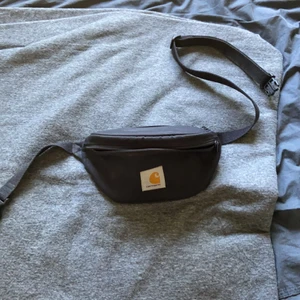 Carhartt Fannypack - Skitfet och smidig väska från carhartt med justerbart band med 3 stora fickor. Används aldrig längre och därför säljer jag den.