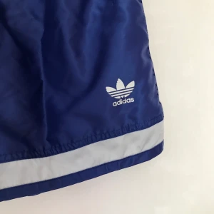 Adidas shorts - Ascoola vintage-style shorts från Adidas. Mörkblå i färgen och med snörning💙 Frakt ligger på 63kr🥳