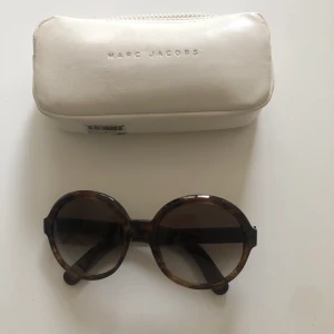 Marc Jacobs solglasögon - Supercoola runda solglasögon från Marc Jacobs. Färgen är i mörkgrå/brun.