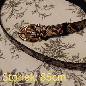 Skärp  - Skärp med beige ormtryck och guldiga detaljer. 85 cm långt. Använt en gång! 🐍Kika gärna in vad mer jag säljer! 💞