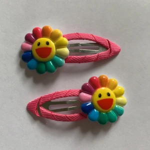 takashi murakami hårspänne - rosa hårspänne med regnbågs blomma på. en knock off av takashi murakami blommorna. aldrig använt frakt kostar 11kr