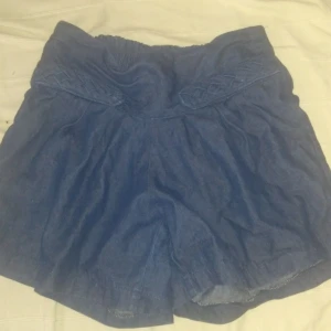 Retro jeansshorts - Mörkblå mjuka jeanshorts med hög midja och resår bak. Storlek saknas men passar 38-40.