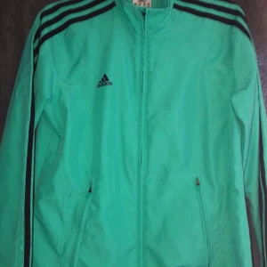 Adidas tränings tröja med dragkedja - Adidas tröja med dragkedja i träningsmaterial men snygg till vardags också, den är i storlek 36 (S). 