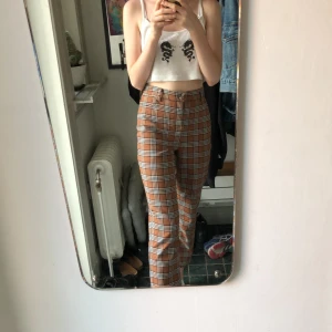 Rutiga byxor från Monki  - Rutiga byxor från Monki. Jättefint skick. Färgen är ungefär som i sista bilden. Strl 36 och jag på bilden har xs eller w25. Betalning sker via swish och de kan både fraktas eller hämtas upp. Fråga gärna efter mått eller fler bilder så fixas det. 