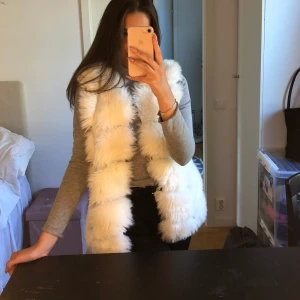 Vit pälsväst - Jättefin vit pälsväst (fuskpäls), oanvänd av mig men är köpt second hand så vet inte hur mycket använd den är innan! Står ej storlek men skulle säga att den passar XS-M (jag är en S). Pris kan diskuteras vid snabb affär! 