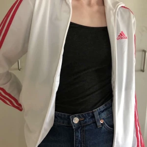 Adidas wc-t jacka - Vit adidas ”jack” med rosa ränder. Inte mycket använd och i väldigt skönt material! Frakten ingår i priset.